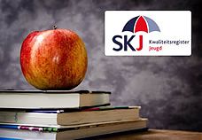 Een appel, een stapel boeken én het logo van SKJ - Kwaliteitsregister Jeugd