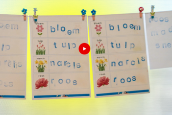 Waslijn waaraan vellen papier hangen met plaatjes en gestempelde woorden