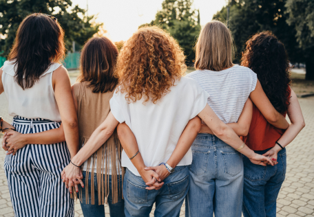 Vijf vrouwen die je op de rug ziet die elkaar vasthouden